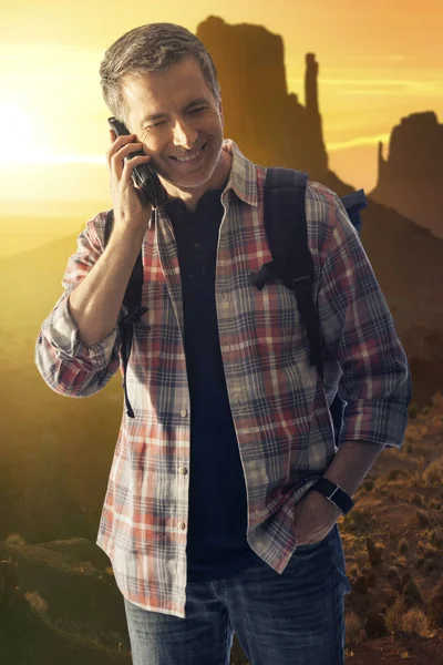 男子在沙漠中徒步旅行 用手机打电话 可以接收网络信号 能够使用手机是获得帮助或指示的生存工具 — 图库照片