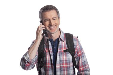 Erkek turist ya da bir yürüyüşçü aramak için bir cep telefonu kullanarak ya da o seyahat böylece bir rideshare mesaj. Adam sırt çantası giyiyor ve akıllı telefon kullanıyor. Beyaz arka planda yalıtılmış. 