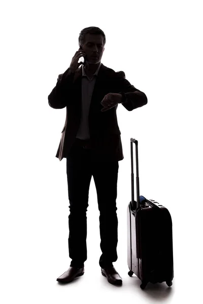 携帯電話でライドシェアを求めるビジネスマンのシルエット 彼はまるで空港から到着したかのように荷物を待っている 複合材料の白い背景に分離 — ストック写真