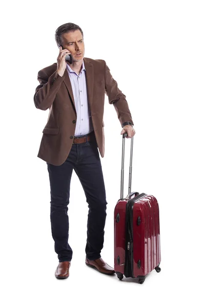 商人在电话中抱怨取消航班或要求晚点乘坐共享航班 他正带着行李等着 好像他刚到或准备出发 — 图库照片