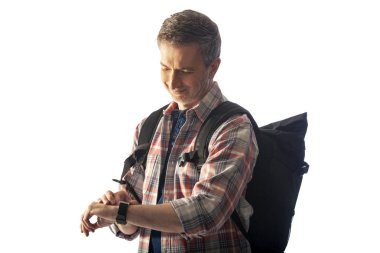 Orta yaşlı yürüyüşçü bir akıllı saat sağlık uygulamaları ile kalp hızı nabız kontrol. O commposite arka planlar ile uyum için günbatımı ışık ile aydınlatılmış.