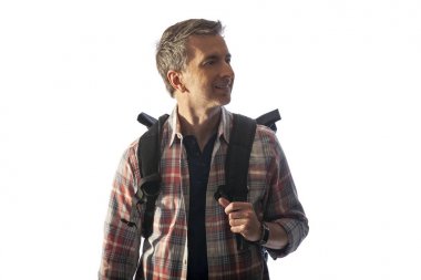 Gün batımında yürüyen bir sırt çantası ile Orta Yaşlı erkek turist. Kompozitler için beyaz bir arka plan üzerinde izole edilmiş. Bu yaşlı olgun erkekler için sağlıklı yaşam tarzı faaliyetleri tasvir. 