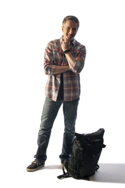 Orta Yaşlı turist gün batımında yürüyüş veya trekking için bir sırt çantası hazırlanıyor. Kompozitler için beyaz arka plan üzerinde izole edilmiş..