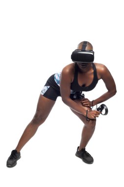 Sanal gerçeklik kulaklık takan ve vr fitness egzersizleri yapan değnek denetleyicileri tutan siyah kadın. Oyun eğlence ve sağlıklı fiziksel aktivite için bir spor simülasyon video oyunu. 
