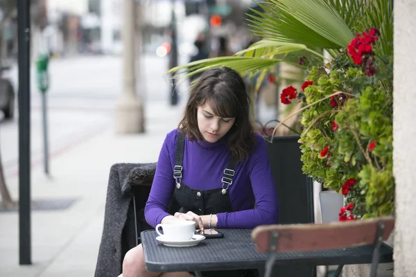 Vrouw Zit Een Openluchtrestaurant Met Behulp Van Een Mobiele Telefoon — Stockfoto