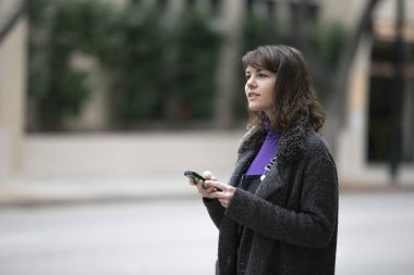 Genç kadın cep telefonu uygulaması kullanarak ve gps navigasyon için online harita kontrol bir rideshare veya yaya turist bekliyor. Şehir hayatını ve milenyumların nasıl seyahat ini anlatıyor.