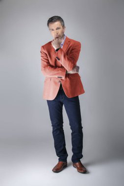 Sonbahar giyim koleksiyonu için mercan renkli spor ceket veya ceket giyen orta yaşlı moda modeli. 2019 için modern renkli giyim tarzı tasvir. 