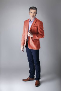 Sonbahar giyim koleksiyonu için mercan renkli spor ceket veya ceket giyen orta yaşlı moda modeli. 2019 için modern renkli giyim tarzı tasvir. 