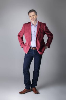 Orta yaşlı Kafkas işadamı modern sonbahar koleksiyonu tarzı bordo veya kırmızı ceket giyiyor şık görünümlü. Kendine güvenen ve olgun şık moda tasvir eder. Katalog görünümü için stüdyoda çekim. 