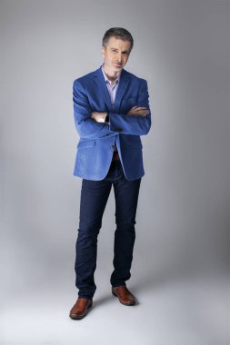 Orta yaşlı Kafkas işadamı modern sonbahar koleksiyonu tarzı mavi ceket giyiyor şık görünümlü. Kendine güvenen ve olgun şık moda tasvir eder. Katalog görünümü için stüdyoda çekim. 