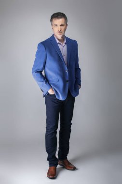 Orta yaşlı Kafkas işadamı modern sonbahar koleksiyonu tarzı mavi ceket giyiyor şık görünümlü. Kendine güvenen ve olgun şık moda tasvir eder. Katalog görünümü için stüdyoda çekim. 