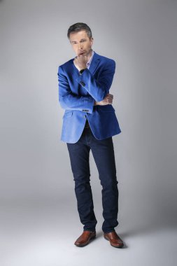 Orta yaşlı Kafkas işadamı modern sonbahar koleksiyonu tarzı mavi ceket giyiyor şık görünümlü. Kendine güvenen ve olgun şık moda tasvir eder. Katalog görünümü için stüdyoda çekim. 