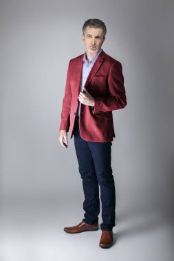 Orta yaşlı Kafkas işadamı modern sonbahar koleksiyonu tarzı bordo veya kırmızı ceket giyiyor şık görünümlü. Kendine güvenen ve olgun şık moda tasvir eder. Katalog görünümü için stüdyoda çekim. 