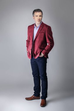 Orta yaşlı Kafkas işadamı modern sonbahar koleksiyonu tarzı bordo veya kırmızı ceket giyiyor şık görünümlü. Kendine güvenen ve olgun şık moda tasvir eder. Katalog görünümü için stüdyoda çekim. 