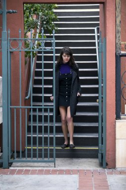 Genç kadın üniversite öğrencisi sokağa Kiralık bir daire ya da daire yurttan bağımsız seyir içine merdivenlerden aşağı gidiyor. Kentsel ve şehir yaşam tarzı ve Konut kira tasvir. 