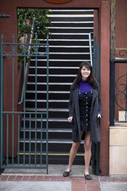 Genç kadın üniversite öğrencisi sokağa Kiralık bir daire ya da daire yurttan bağımsız seyir içine merdivenlerden aşağı gidiyor. Kentsel ve şehir yaşam tarzı ve Konut kira tasvir. 