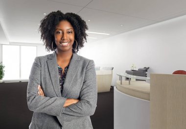 Black African American businesswoman in an office looking confident or arrogant.  She is an owner or an executive of the workplace.  Depicts careers and startup business.  clipart