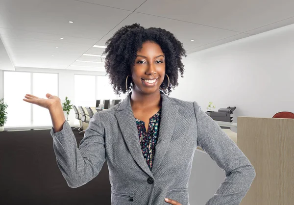 Black African American businesswoman in an office advertising or presenting something.  She is an owner or an executive of the workplace.  Depicts careers and startup business.