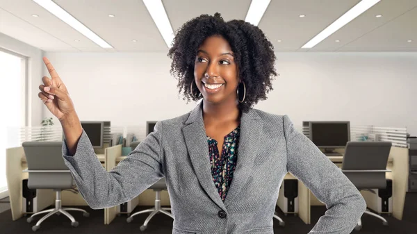 Black African American businesswoman in an office advertising or presenting something.  She is an owner or an executive of the workplace.  Depicts careers and startup business.