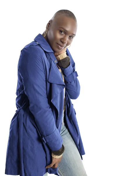 Black African American fashion model with bald hairstyle confidently posing with a vibrant blue colored jacket for fall collection.  Depicts fashion design and clothing apparel
