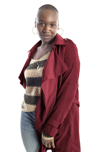 Black African American fashion model with bald hairstyle confidently posing with a red colored jacket for fall collection.  Depicts fashion design and clothing apparel