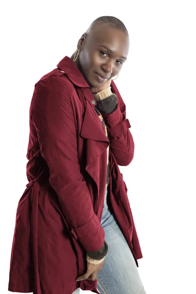 Black African American fashion model with bald hairstyle confidently posing with a red colored jacket for fall collection.  Depicts fashion design and clothing apparel