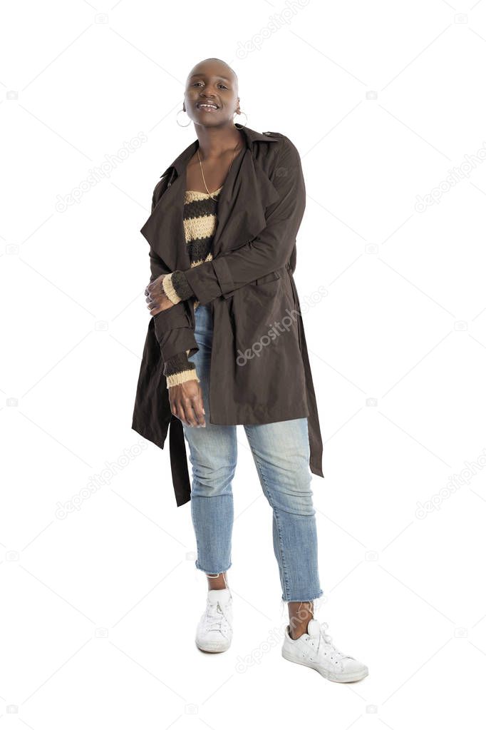 Black African American fashion model with bald hairstyle confidently posing with a coffee brown colored jacket for fall collection.  Depicts fashion design and clothing apparel