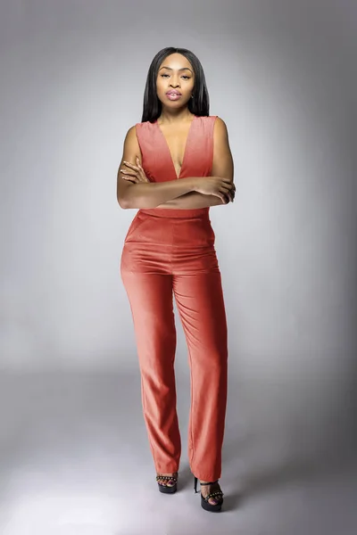 秋のコレクションカタログのためのスタジオでピンクやオレンジの服でポーズ美しい黒アフリカ系アメリカ人のファッションモデル 彼女は自信を持ってノースリーブのトップとマッチングパンツを示しています — ストック写真