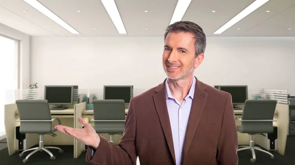 一个白发苍苍的中年商人 穿着一件棕色的夹克站在办公室里 描述初创公司和企业业务 他正在做广告或展示一些东西 — 图库照片
