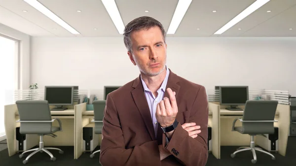 一个白发苍苍的中年商人 穿着一件棕色的夹克站在办公室里 描述初创公司和企业业务 他正在做一个赚钱的手势 — 图库照片