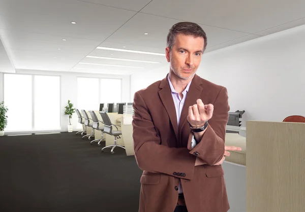 一个白发苍苍的中年商人 穿着一件棕色的夹克站在办公室里 描述初创公司和企业业务 他指着前去 — 图库照片