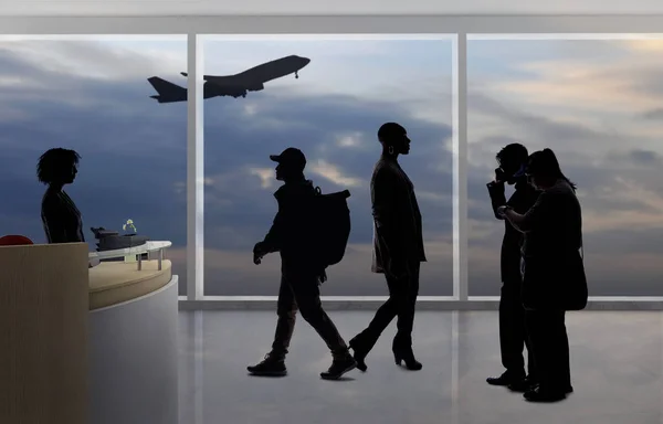 Silhouettes of passengers waiting in line at an airport check in counter with an attendant checking real ID or passport and luggage.