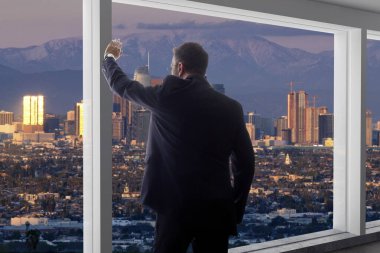 Takım elbiseli bir işadamı ofis penceresinden Los Angeles şehir merkezindeki binalara bakıyor. Adam politikacıya benziyor. Belediye başkanı, mimar ya da emlakçı gibi..
