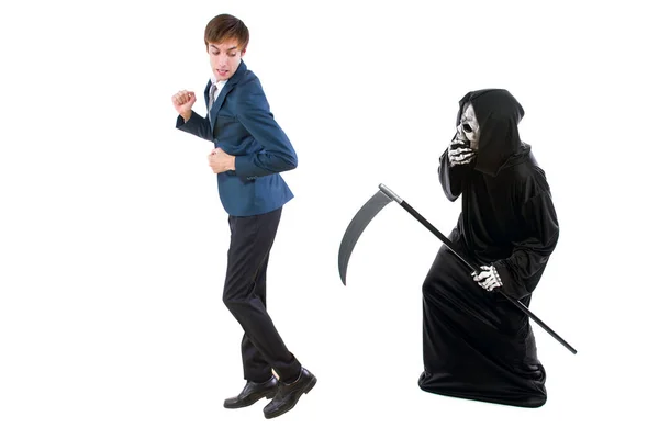 Man in a Halloween grim reaper ghost costume chasing, mocking and making fun of scared businessman running away.  Can also depict death following a man as a metaphor for life insurance.
