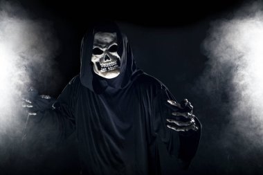 Sisli sisin içinden korkunç görünümlü Azrail hayaleti geliyor. Korkunç iblis, ölüm ve kötülüğü tasvir eder ve yaygın bir Cadılar Bayramı temasıdır..  