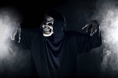 Sisli sisin içinden korkunç görünümlü Azrail hayaleti geliyor. Korkunç iblis, ölüm ve kötülüğü tasvir eder ve yaygın bir Cadılar Bayramı temasıdır..  