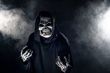 Sisli sisin içinden korkunç görünümlü Azrail hayaleti geliyor. Korkunç iblis, ölüm ve kötülüğü tasvir eder ve yaygın bir Cadılar Bayramı temasıdır..  