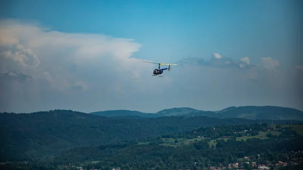 Robinson 44 Raven II helikopteri Polonya 'daki Karkonosze dağları üzerinde uçuyor.