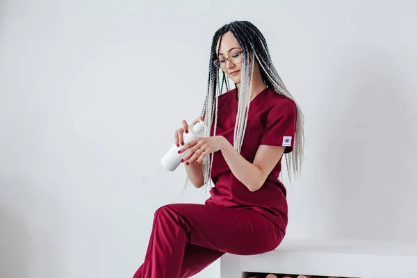 Chica Uniforme Médico Rojo Con Coletas Africanas Comprueba Crema Mano —  Fotos de Stock