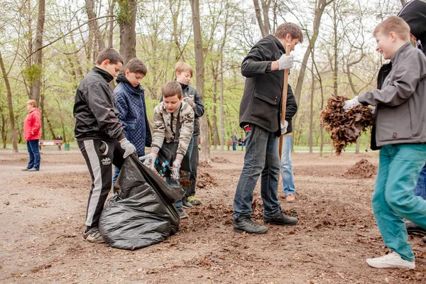 Kiev, Ucrania 16.04.2016 un grupo de personas adolescentes haciendo limpieza de primavera en el parque. adolescentes en el trabajo comunitario al aire libre —  Fotos de Stock