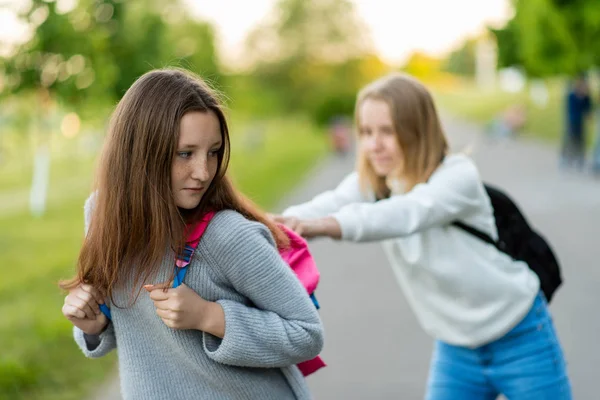 Girls are schoolgirls. Summer in nature. Taking each others bags away. Fight after the lessons. Poor upbringing of adolescents. Problem children. — Stock Photo, Image