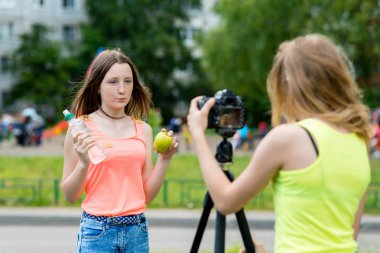 2 meyveler hakkında konuşur. Uygun bir diyet sağlıklı kardeşim yaşıyor. Onun elinde tutan şişe su ve elma. Kayıt vlog ve blog abone. Kayıt video dersini Internet. Kullanma fotoğraf makinesi tripod ile.