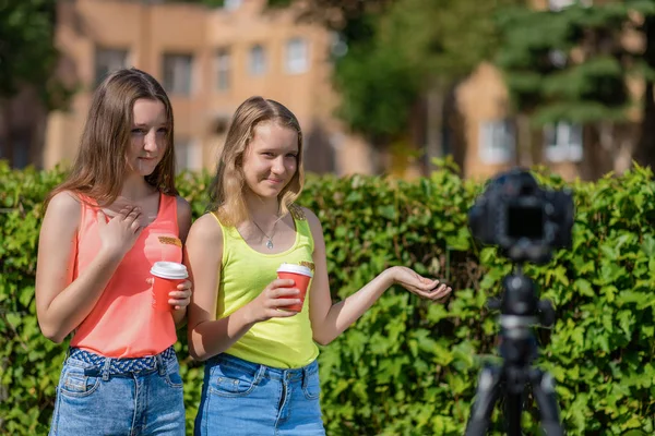 Jonge vriendin meisje. Zomer in de natuur. Schrijft de video. Vertelt over hete thee koffie. Record vlog en blog abonnees. Record Videolessen voor Internet. Gebruik camera met statief. — Stockfoto