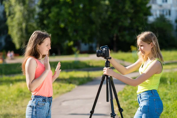 Miúdas adolescentes. Verão na natureza. Eles transmitem ao vivo pela câmara. Registre assinantes vlog e blog. Grave a lição de vídeo para Internet. Use câmera com tripé . — Fotografia de Stock