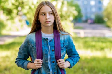 Güzel kız öğrenci kız. Doğa yazın. Sırt çantası arkasında şehirde bekletin. Uzağa arıyorsunuz. Okuldan sonra geri döndü.