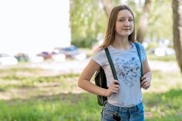Iskolás lány. Nyáron a természet. Mögötte egy hátizsák. Szabad hely, a szöveg. Kemping. Boldogan mosolyog. — Stock Fotó