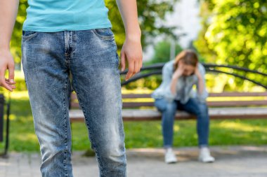Genç adam yakın bir kız var. Arka planda tezgah üzerinde ağlayan ve üzgün kız. Sorun aile ilişkileri kırılması kavramdır.