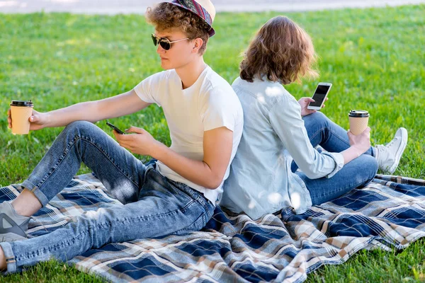 Kız adamla bir battaniye üzerinde oturuyor. Doğa yazın. Elinde bir bardak kahve veya çay tutar. Doğada rahatlatıcı sahiptir. Görünüyor akıllı telefon defa okundu. Sosyal ağlarda iletişim kurar.