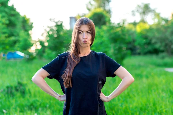 Beautiful summer girl in park on vacation. Gesture hands on the waist. Shows his lips stares sideways. Emotions are fun jokes. Expression of a dissatisfied person. Asian woman with long hair. — Stock Photo, Image