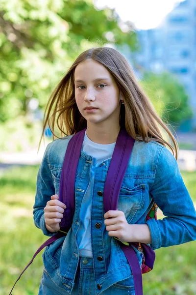 Bir genç kız. Doğa yazın. Yakın çekim. Denim giyim renkli sırt çantası arkasından. Okula kavramı verir. — Stok fotoğraf